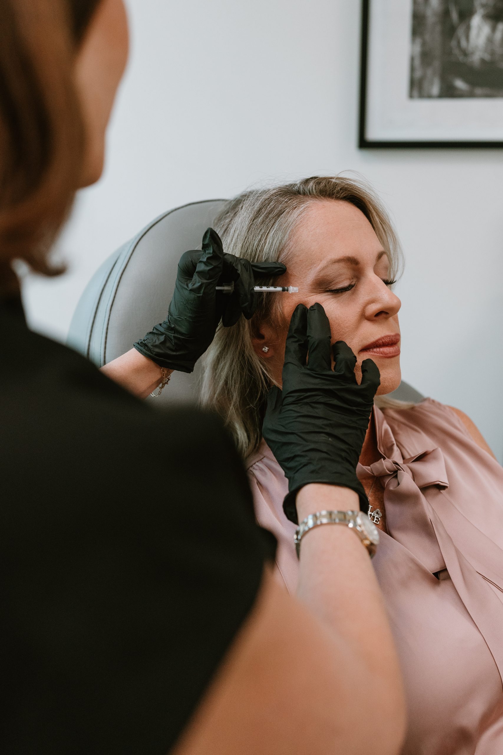 revived medical aesthetics staff member giving an injection to a blonde patient